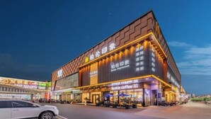 Un edificio moderno con insegne illuminate, tra cui un caffè chiamato 'luckin coffee'.