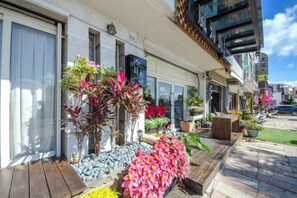 A hotel with a covered outdoor area, potted plants, and a wooden deck. - Kenting Lan Bay Hotel (Pingtung)