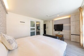 A hotel room with a bed, a TV, a desk, and a wardrobe. - Kenting Lan Bay Hotel (Pingtung)
