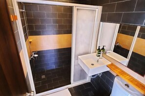 A bathroom with a shower, a sink, and a toilet. - Kenting Lan Bay Hotel (Pingtung)