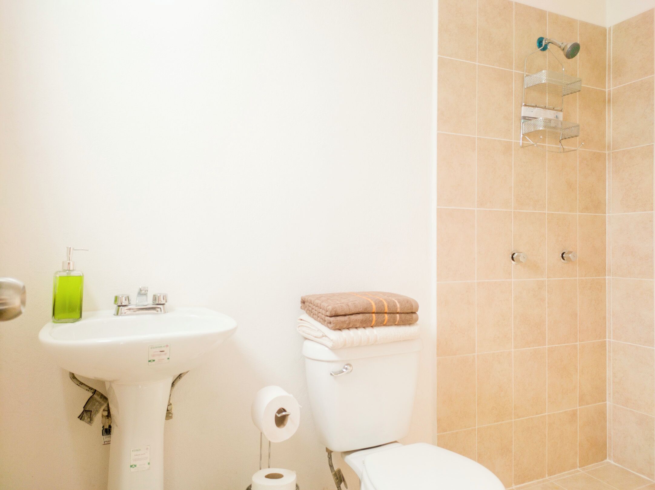 A bathroom with a sink, toilet, and shower area.