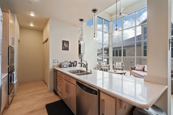 A modern kitchen with a large window, built-in appliances, and a dining area with a view.