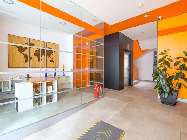 A modern reception area with a desk, computer, and a world map on the wall.
