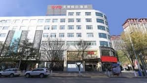 A modern hotel building with a prominent 'OYO' sign, featuring multiple floors and a curved facade. - OYO Jingbian County Tianli Holiday Hotel (Jingbian County)