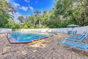 A swimming pool with lounge chairs and a shaded area. - Fernandina Beach Condo w/ Pool + Path to Beach! (Fernandina Beach)