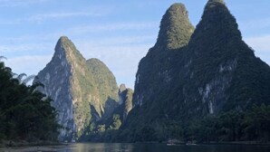A natural landscape with limestone karst formations and a body of water. - Wonton Hotel Yangshuo (Yangshuo)