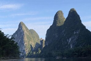 A natural landscape with limestone karst formations and a body of water.