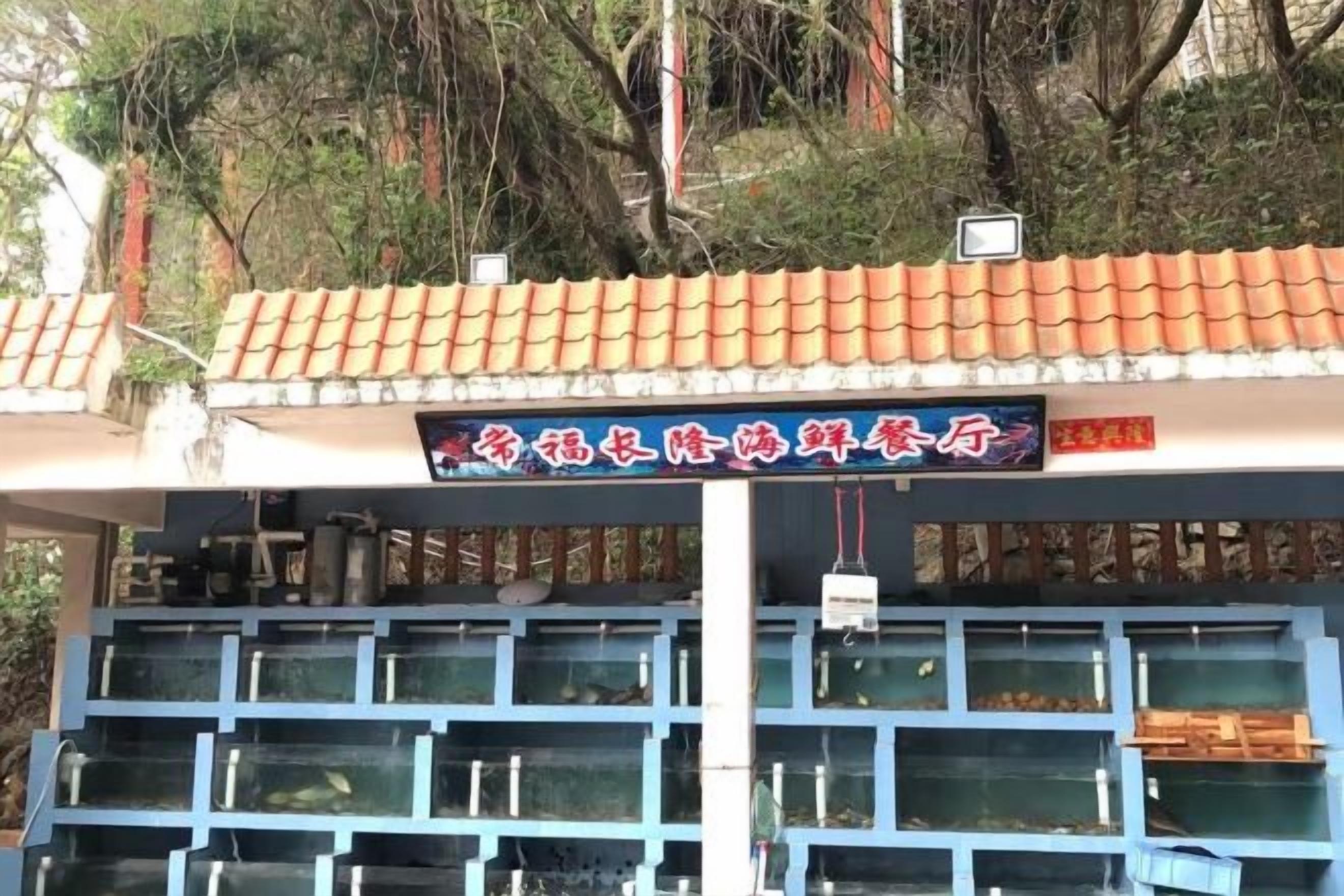 Un bâtiment doté d’un toit en tuiles et de plusieurs aquariums.
