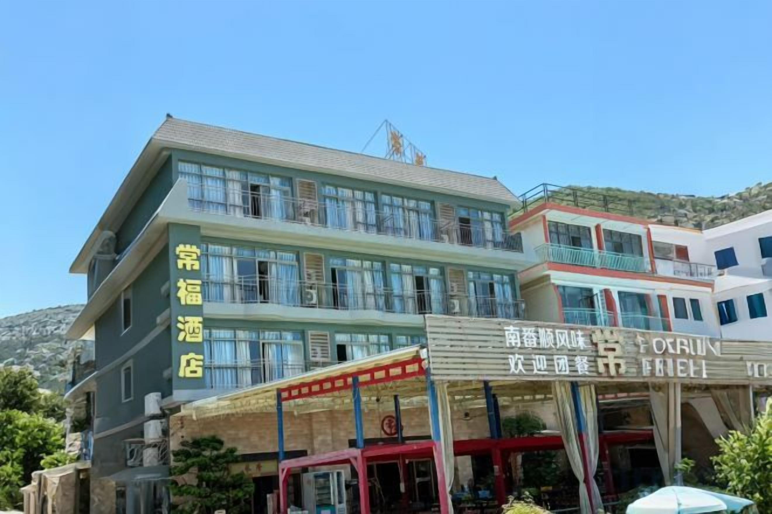 A multi-story hotel with a prominent sign for the 'Feng Hotel' and a separate building labeled 'Feng Hotel Restaurant.'