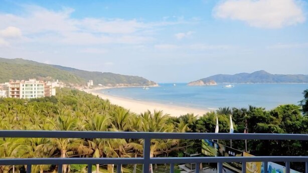 Vista sulla costa con spiaggia, edifici e vegetazione.
