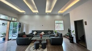 Un soggiorno moderno con un divano componibile, un tavolino in vetro e illuminazione a incasso.