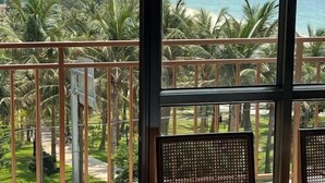 Un balcone con vista su una spiaggia e palme.