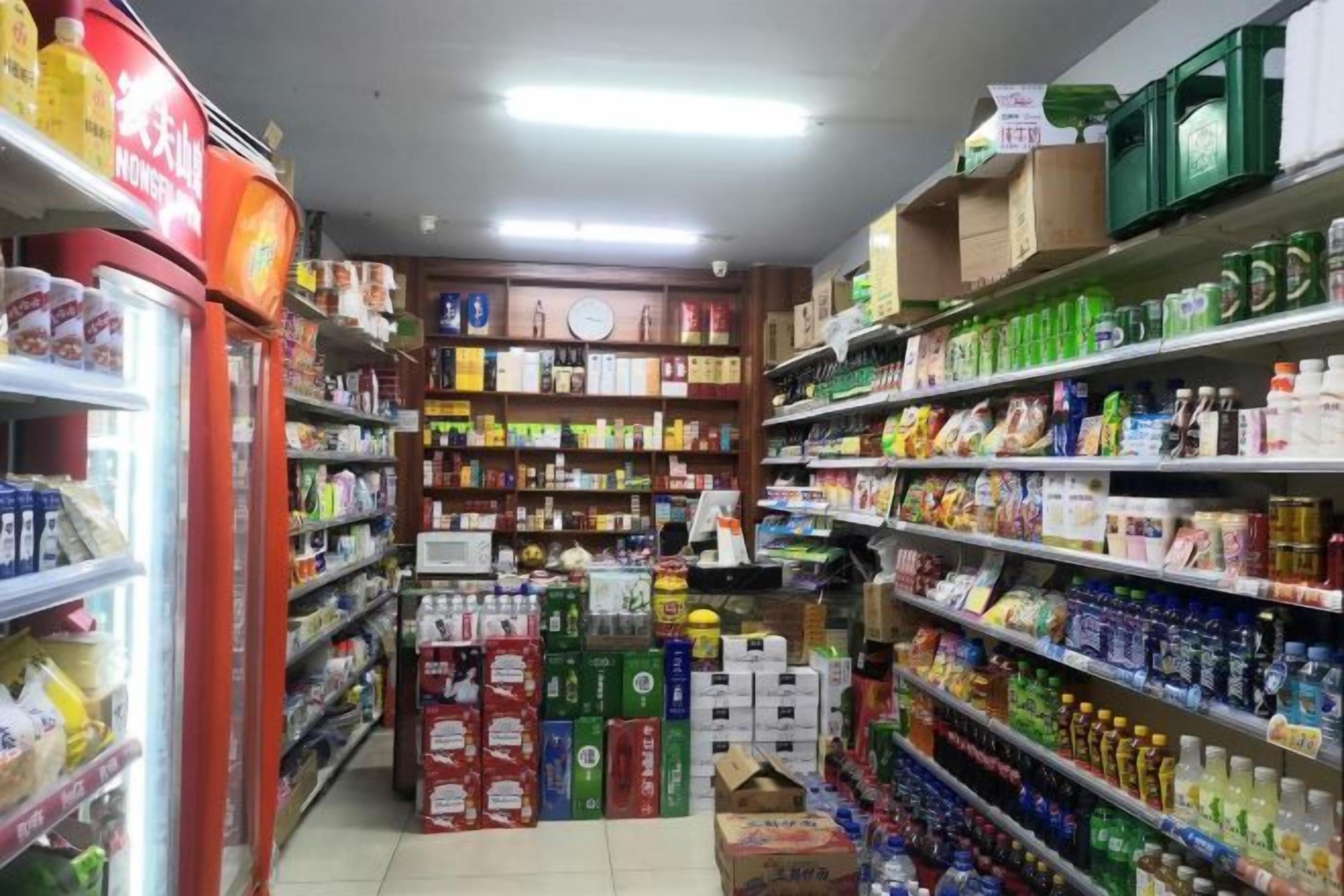 Un rayon d’épicerie où les étagères sont remplies de divers produits, notamment des boissons, des en-cas et des articles ménagers.