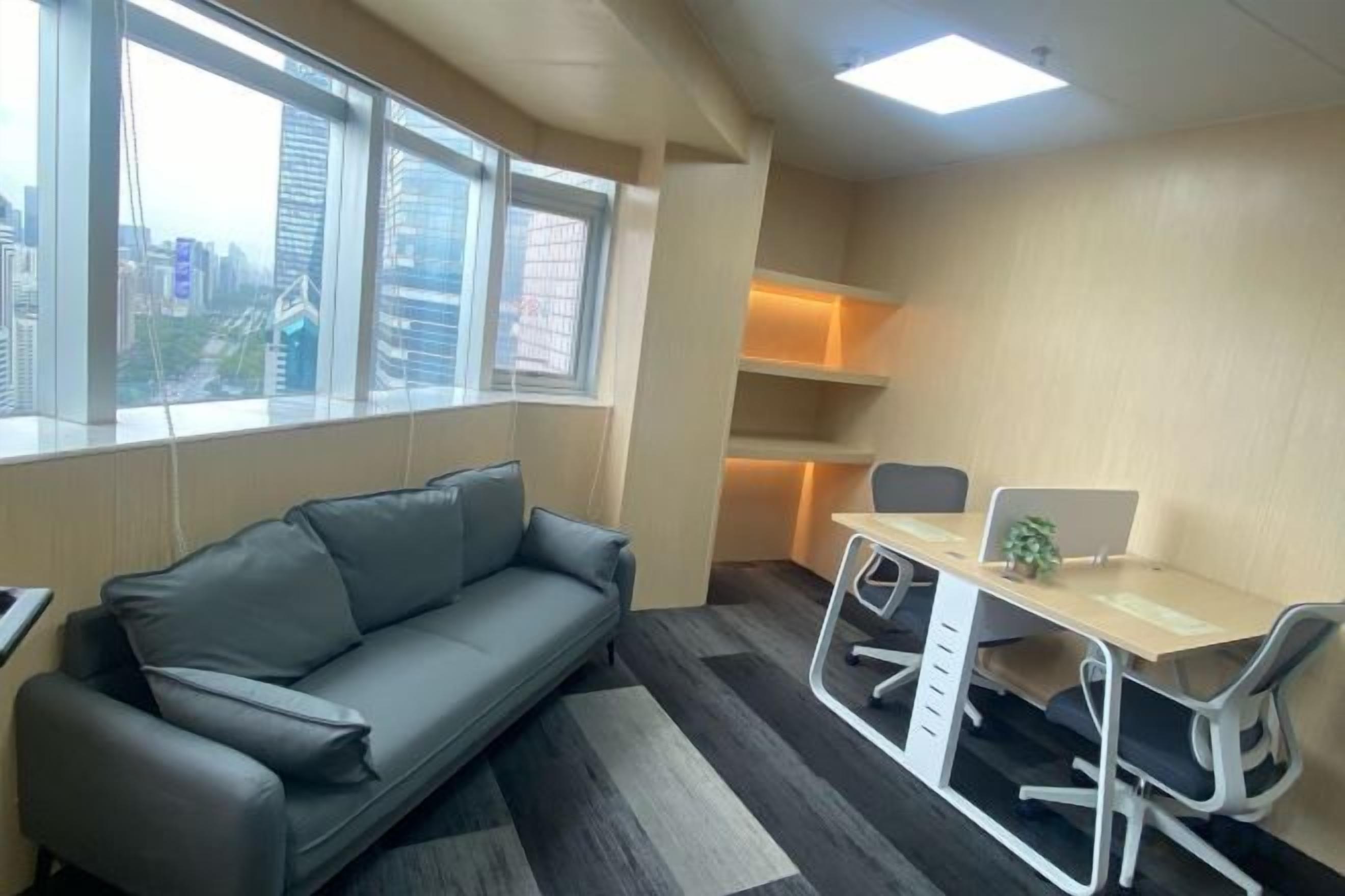 A modern office space with a sofa, a desk, and chairs.