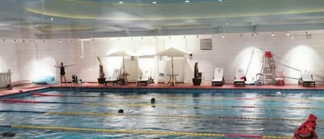 Una piscina interior con carriles de natación, sillones de descanso y un puesto de socorristas.