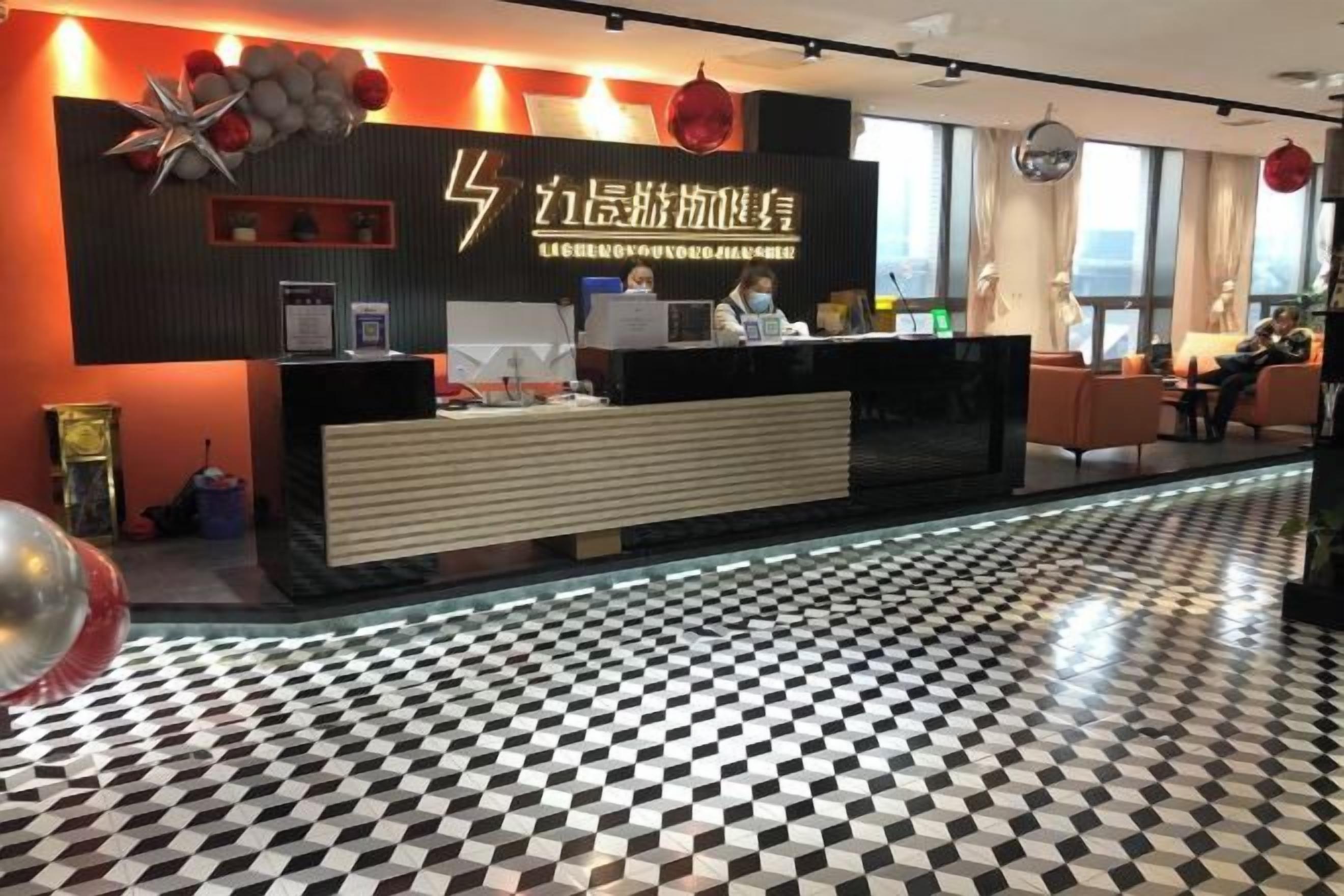 A hotel reception area with a check-in counter, a black and white checkered floor, and a large window providing a view.