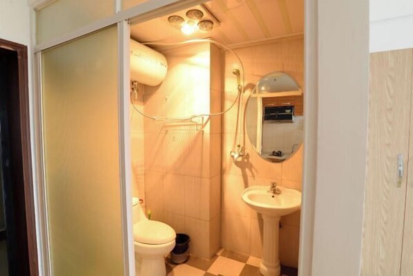 Ein kleines Badezimmer mit Toilette, Waschbecken und Dusche.