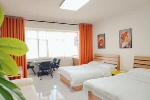 Ein Hotelzimmer mit zwei Betten, einem Schreibtisch und einem Stuhl.