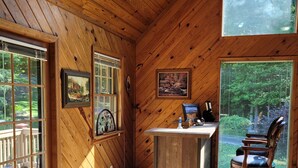 Un intérieur en bois avec un bureau, une chaise et de grandes fenêtres.