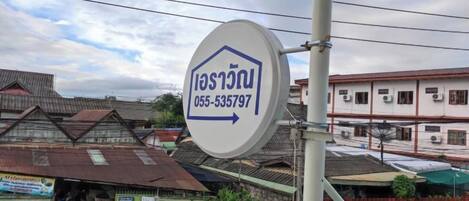A sign with a house icon and a phone number, indicating a property for sale or rent.