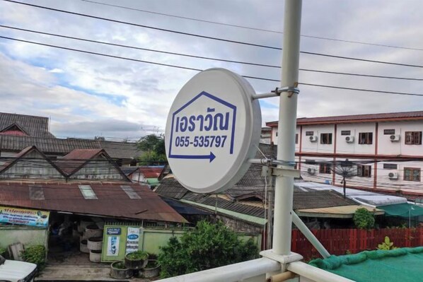 A sign with a house icon and a phone number, indicating a property for sale or rent.