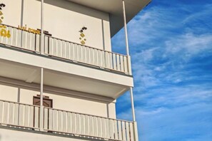 Un edificio de varios pisos con balcones y cielo despejado.