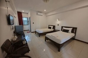 A hotel room with two beds, a desk, a chair, a TV, and an air conditioning unit. - Erawan Place (Mae Sot)