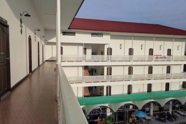 A multi-story building with balconies, a covered courtyard, and a red roof. - Erawan Place (Mae Sot)