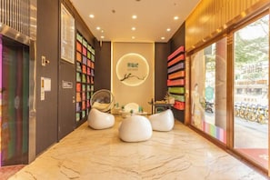 A hotel lobby with a marble floor, a reception desk, and a large window with a view of the street. - 7 Days Premium Hotel(Shenzhen North Station Yicheng Center Branch) (Shenzhen)