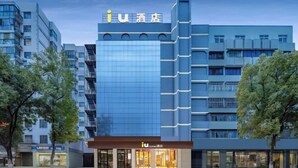 A modern hotel with a prominent 'iU' logo, multiple floors, and a glass facade. - IU Hotels (Jingshan)