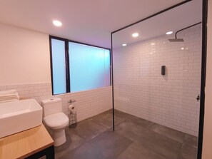 A modern bathroom with a toilet, sink, and shower area.