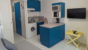 A compact kitchen with a washing machine, a microwave, and a small coffee maker. - Sol-y-Days Floralies 2, Studio with terrace and swimming pool (Le Grau-du-Roi)
