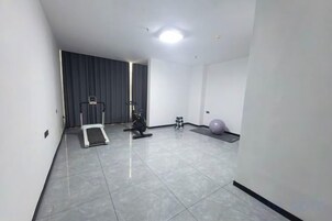 A room with a treadmill, exercise ball, and a small step platform.