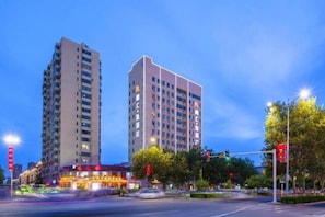 A multi-story building with a modern design, located at a city intersection.