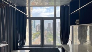 A modern hotel room with a large window, a bed, a desk, and a bathroom. - Korla Ronghui Yi Hotel (Xiangli Avenue Food Street Branch) (Korla)