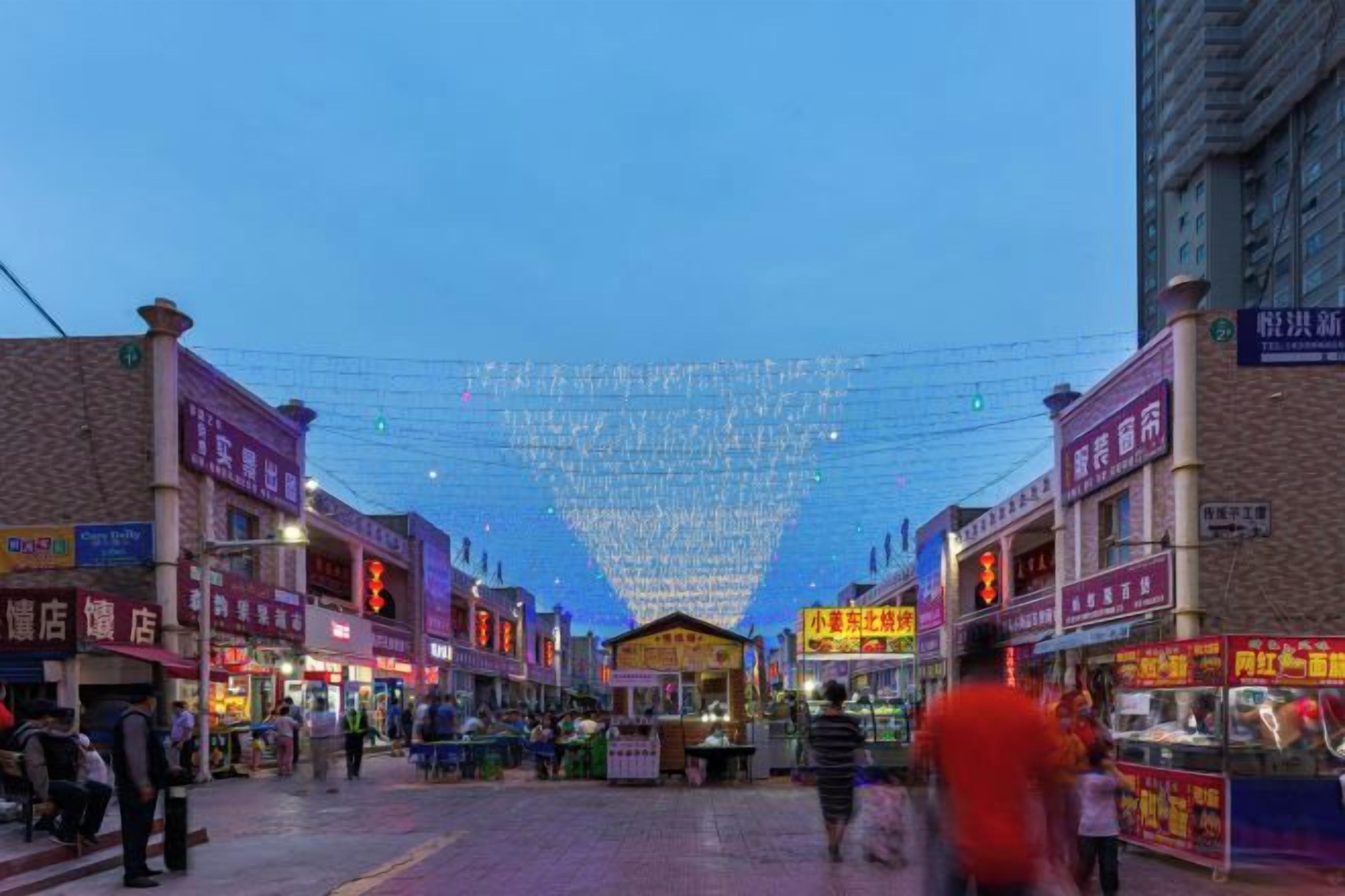 A busy street with shops and people walking.