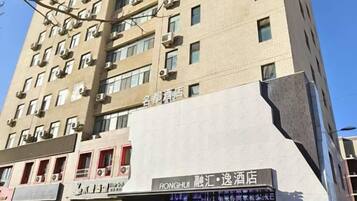 A multi-story building with a modern architectural design, featuring a prominent signage for a hotel named 'RONGHUI' and a restaurant named 'RONGHUI'.