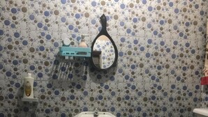A bathroom with a sink, toilet, and mirror.