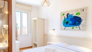 A hotel room with a large bed, a painting on the wall, and a window. - HOTEL ARISTON (Piombino)