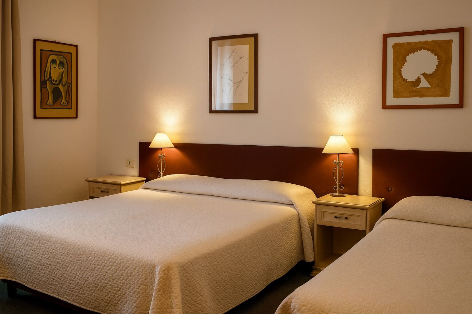 A hotel room with two beds, each with a nightstand and a lamp. There are framed artworks on the walls.