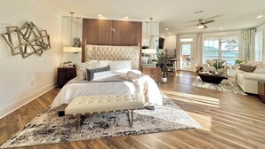 Un dormitorio amplio con una cama grande, un comedor y vistas al exterior.