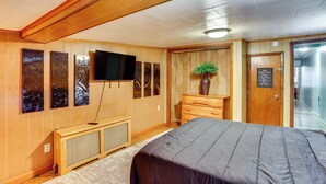 A hotel room with wooden paneling, a bed, a television, artwork on the wall, and a sign on the door. - Playroom & Fenced Yard: Mt Carmel Family Home! (Mt Carmel)