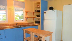 A compact kitchen with a sink, a microwave, a refrigerator, and a wooden table. - Gunnadoo, Moonta Bay (Moonta Bay)