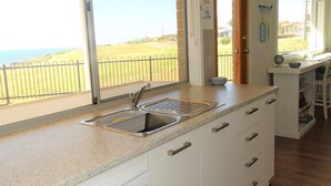 Una cocina con un amplio ventanal, un lavamanos y una encimera.