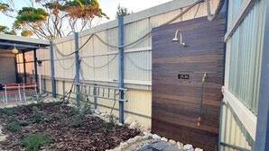 A garden area with a wooden fence, a bench, and a water feature.