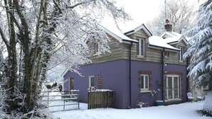A two-story house with a purple exterior and a snow-covered roof. - Countryside Cottage Retreat at Ty'r Cwm Farm (Ammanford)