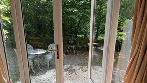 A room with a sliding glass door leading to an outdoor patio area. - Countryside Cottage Retreat at Ty'r Cwm Farm (Ammanford)