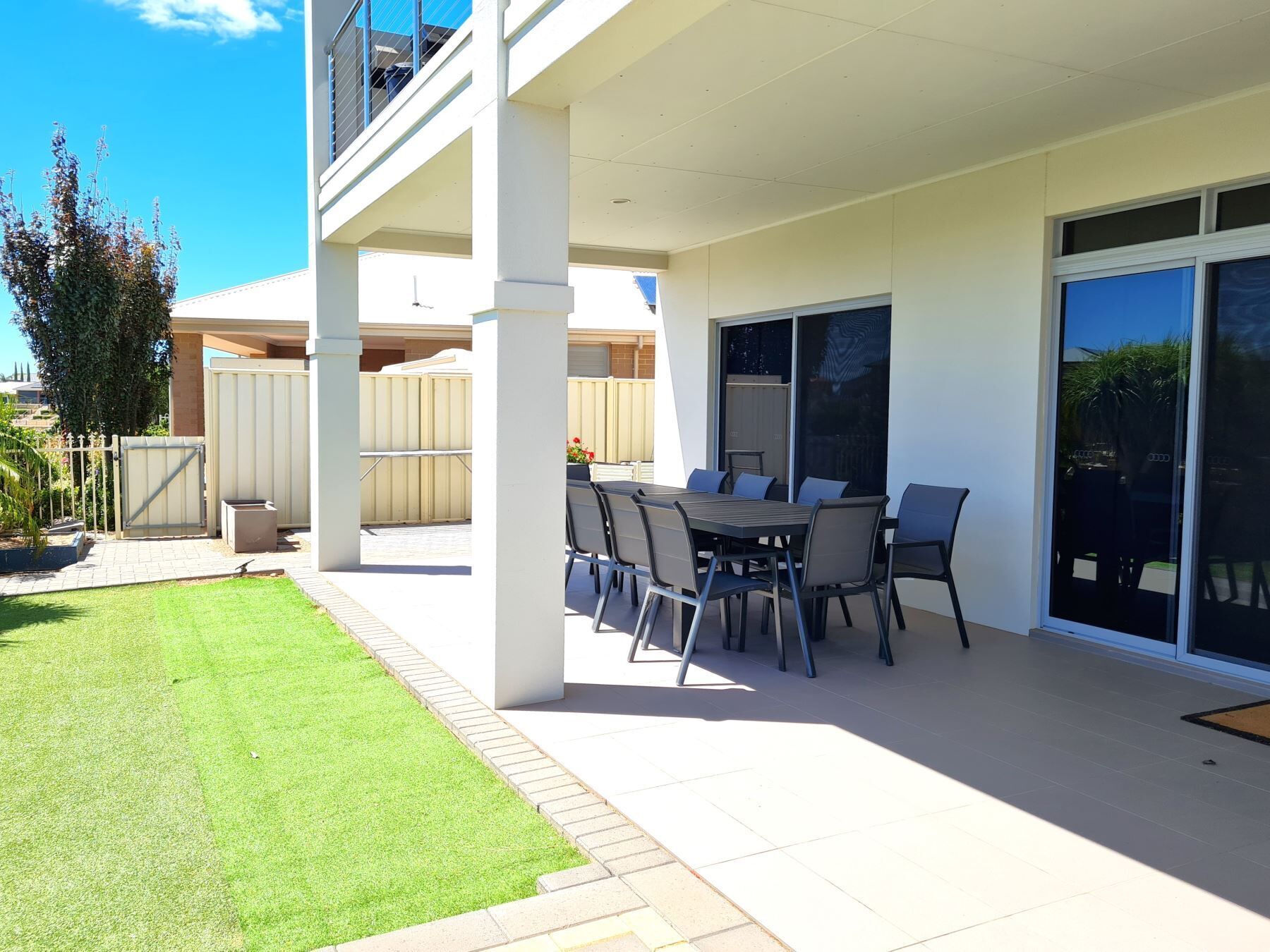 An outdoor patio with a table and chairs, a covered seating area, and a view of the surrounding landscape.