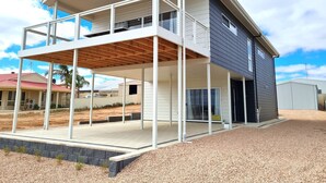A two-story house with a balcony and a covered patio area. - Beachfront Beauty, Moonta Bay (Moonta Bay)