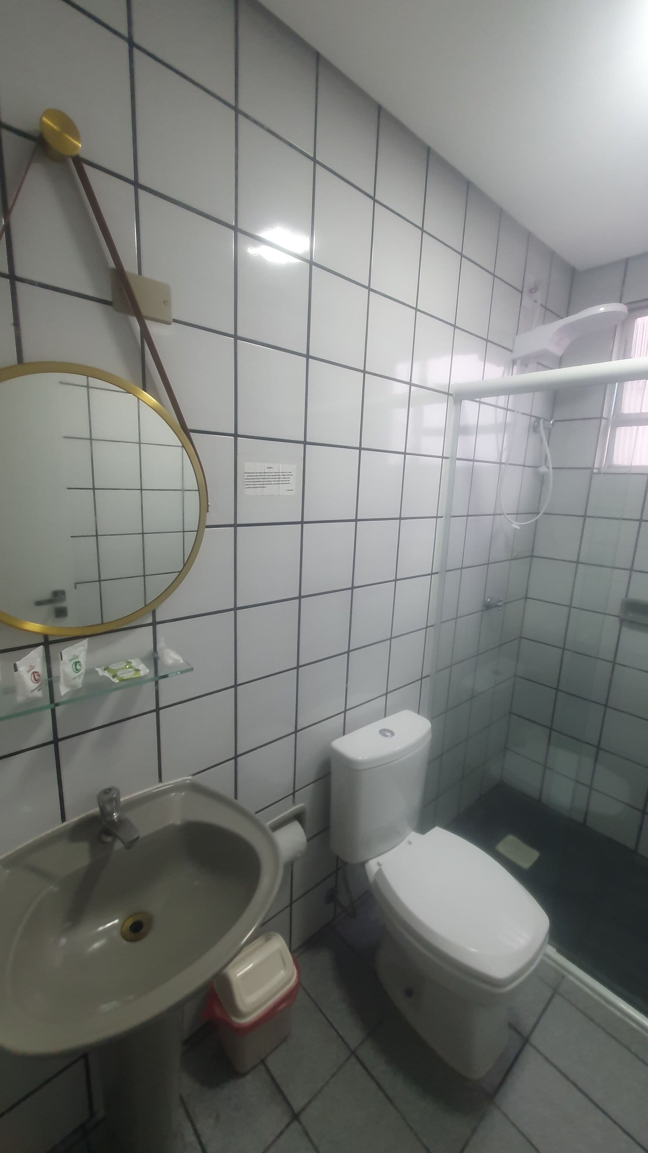 Et badeværelse med vask, toilet og brusebad.